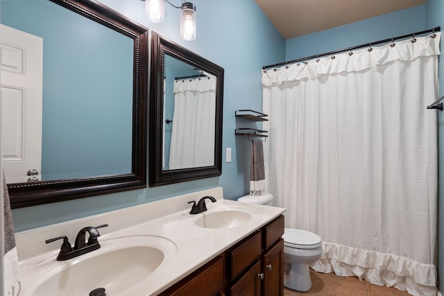 bathroom with vanity, tile patterned flooring, toilet, and curtained shower