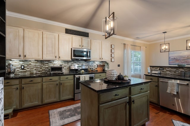 kitchen with pendant lighting, ornamental molding, stainless steel appliances, and dark hardwood / wood-style flooring