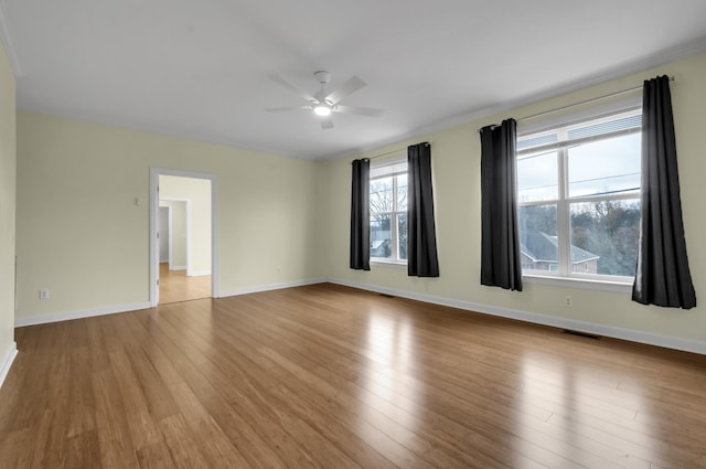 empty room with ceiling fan and light hardwood / wood-style flooring