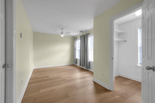 empty room with ceiling fan and light wood-type flooring