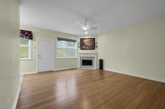 unfurnished living room with ceiling fan, a healthy amount of sunlight, and light wood-type flooring