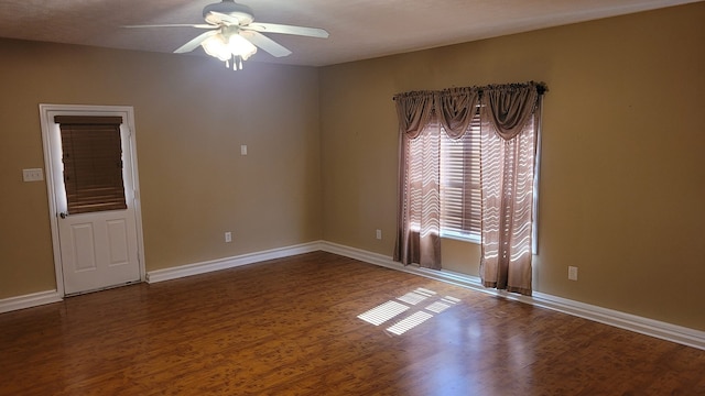 spare room with ceiling fan and dark wood-type flooring