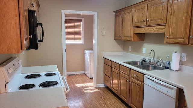 kitchen with light hardwood / wood-style flooring, white appliances, and sink