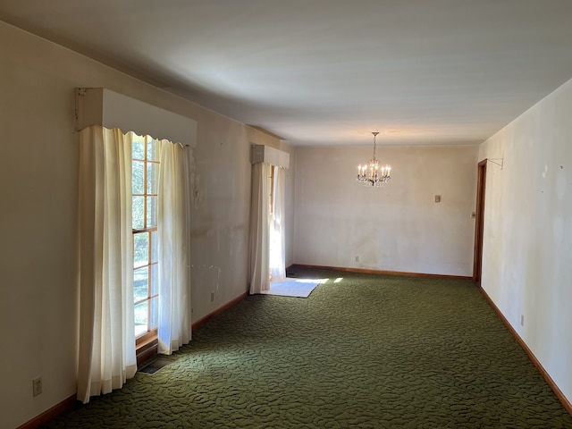 carpeted spare room with a healthy amount of sunlight and a chandelier