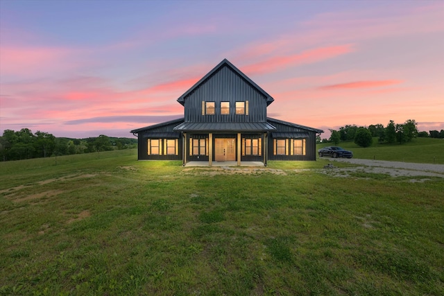 back house at dusk featuring a yard