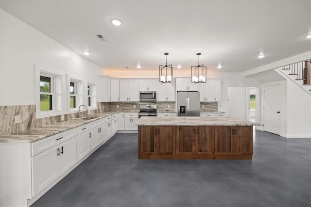 kitchen with tasteful backsplash, sink, stainless steel appliances, a center island, and white cabinetry