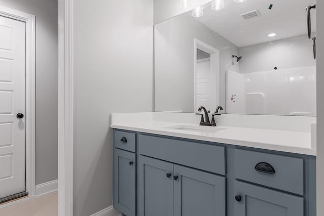 bathroom featuring tile patterned flooring, walk in shower, and vanity