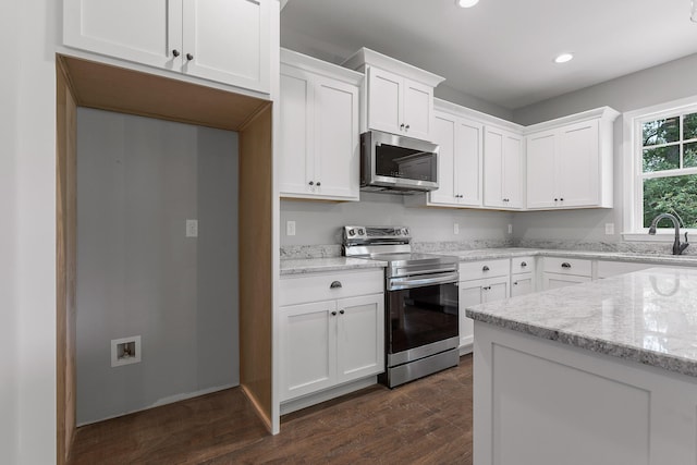 kitchen with sink, stainless steel appliances, light stone countertops, dark hardwood / wood-style floors, and white cabinets