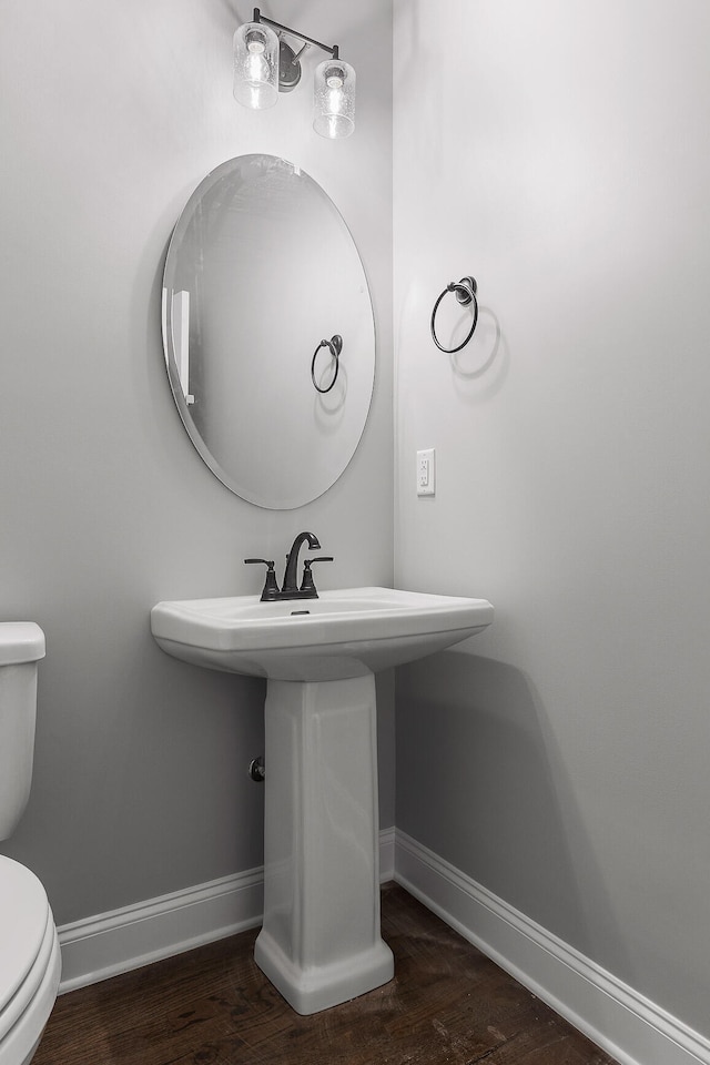 bathroom with hardwood / wood-style floors, sink, and toilet