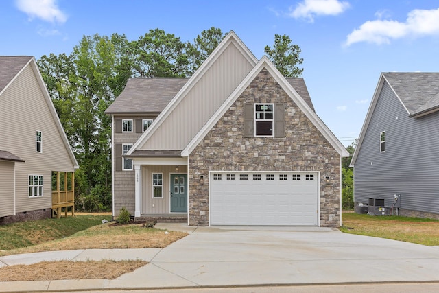 craftsman inspired home featuring a garage and a front lawn