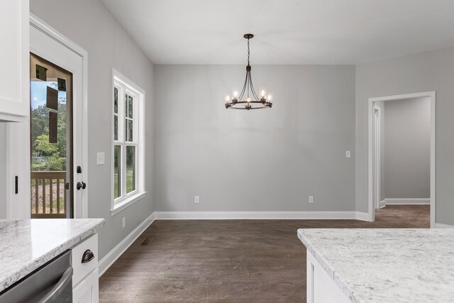 unfurnished dining area featuring dark hardwood / wood-style floors and an inviting chandelier