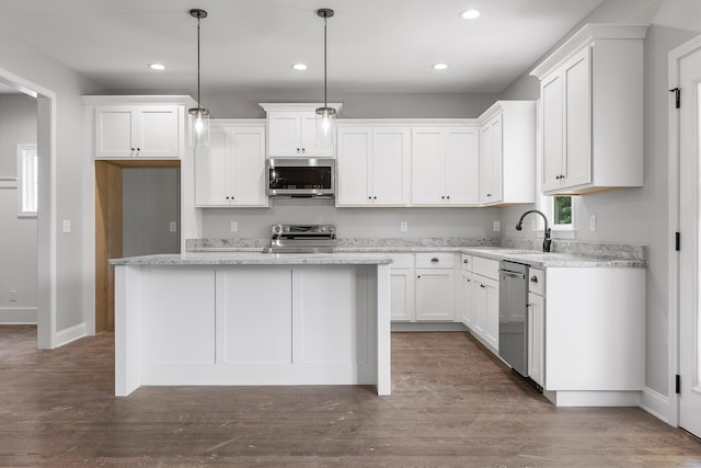 kitchen featuring pendant lighting, a kitchen island, dark hardwood / wood-style flooring, white cabinets, and appliances with stainless steel finishes