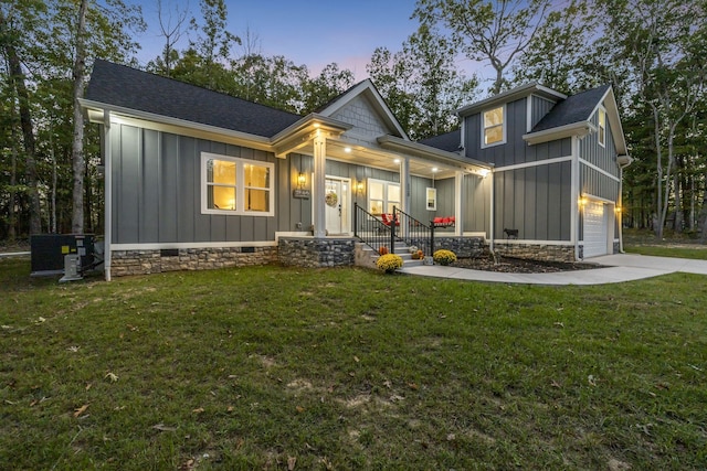 back house at dusk with central AC, a yard, a garage, and a porch