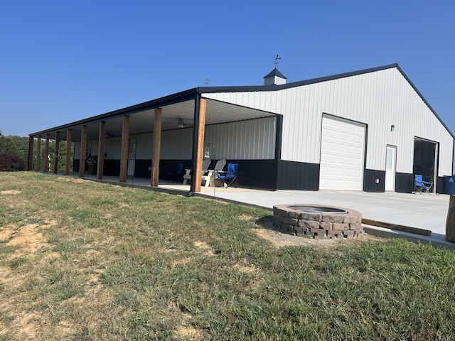 view of outdoor structure featuring a fire pit and a lawn