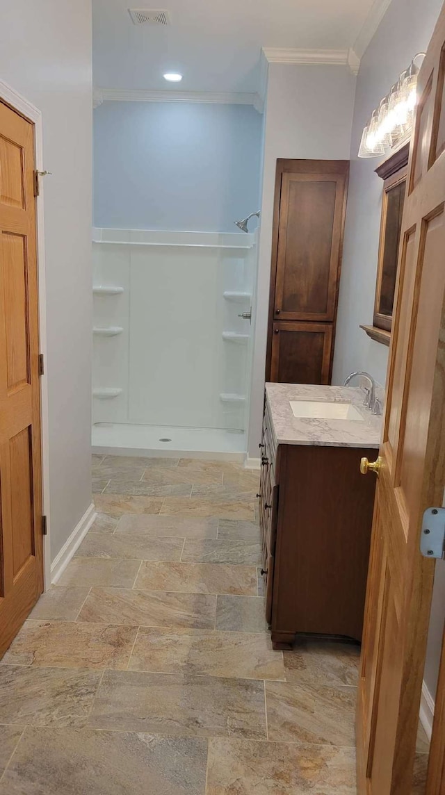 bathroom with ornamental molding, vanity, and a shower