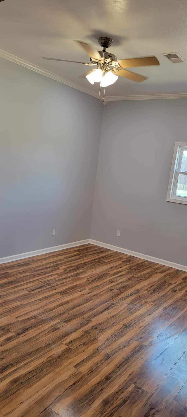 spare room featuring ornamental molding, ceiling fan, and dark wood-type flooring