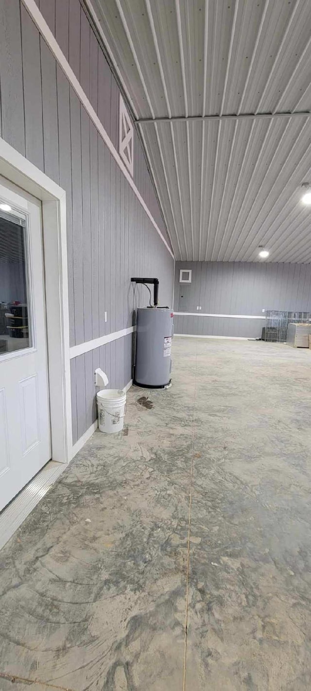 basement with water heater and wooden walls