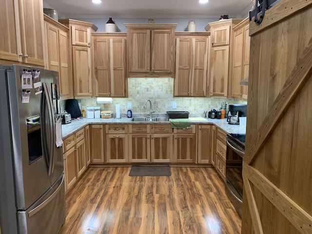 2175 Winsett Rd, Springville, TN 38256 - kitchen with light stone counters, a sink, stainless steel appliances, wood finished floors, and tasteful backsplash
