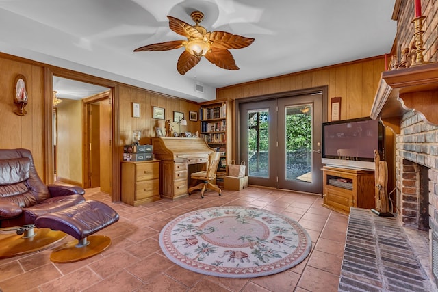 tiled office with a brick fireplace, wooden walls, and ceiling fan