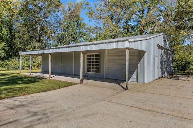 view of outdoor structure featuring a carport and a lawn