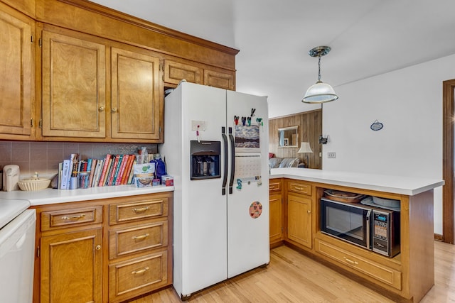 kitchen with tasteful backsplash, white appliances, kitchen peninsula, light hardwood / wood-style flooring, and decorative light fixtures