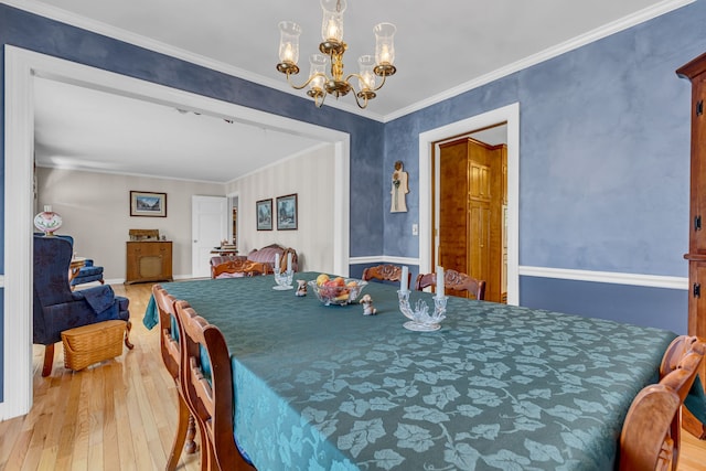 dining room featuring light hardwood / wood-style floors, crown molding, and an inviting chandelier