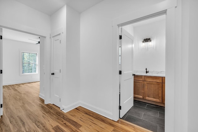 hallway with hardwood / wood-style flooring and sink