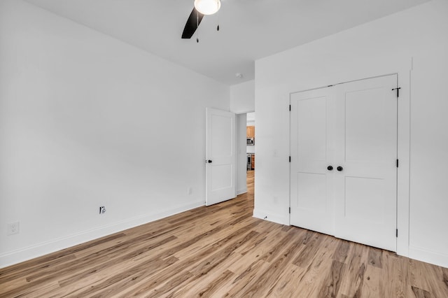 unfurnished bedroom with ceiling fan, a closet, and light hardwood / wood-style flooring