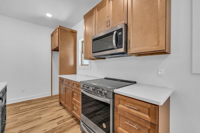 405 Boone Pass, Jasper, TN 37347 - kitchen with appliances with stainless steel finishes, light wood-type flooring, light countertops, brown cabinetry, and baseboards