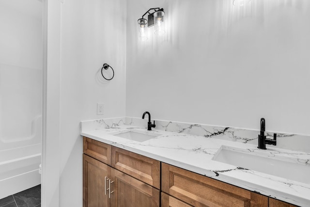 bathroom featuring tile patterned floors, a tub to relax in, and vanity