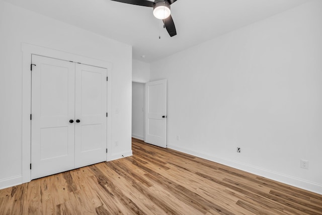 unfurnished bedroom with ceiling fan, a closet, and light hardwood / wood-style floors