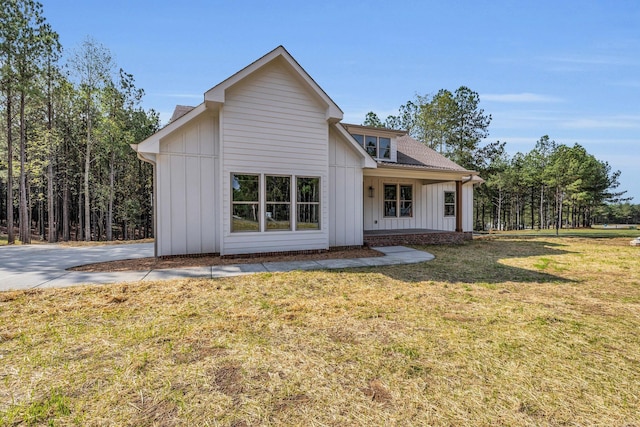 rear view of property featuring a lawn