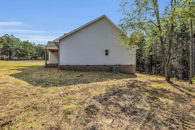 view of side of home with cooling unit and a lawn