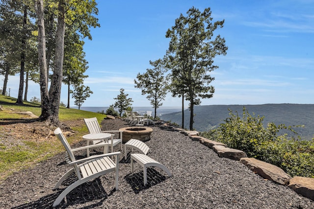 view of yard featuring a water and mountain view and an outdoor fire pit