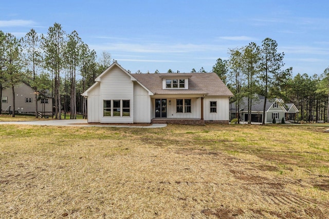 405 Boone Pass, Jasper, TN 37347 - back of house with board and batten siding, a shingled roof, a lawn, and covered porch