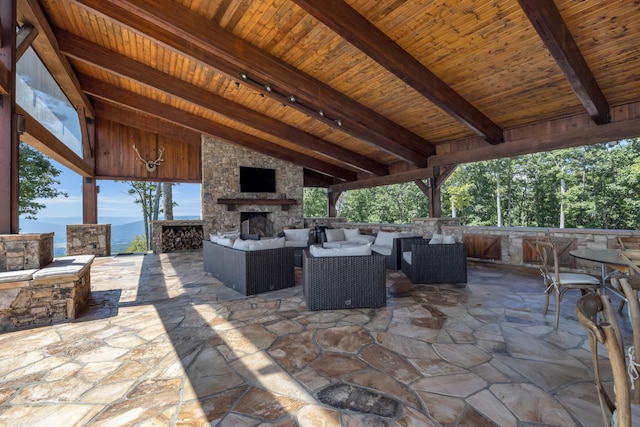 view of patio / terrace with an outdoor living space with a fireplace and a mountain view