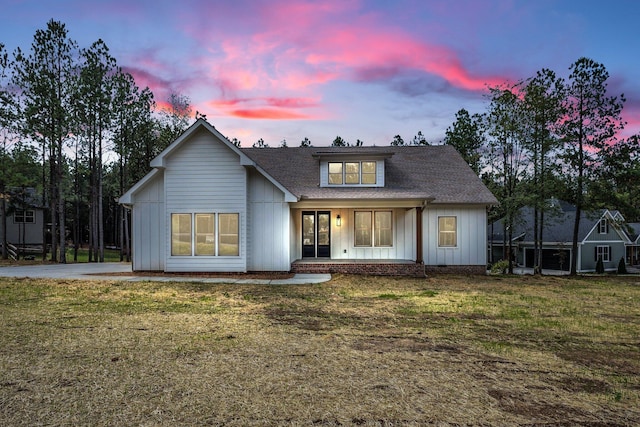 view of front of house featuring a lawn and covered porch