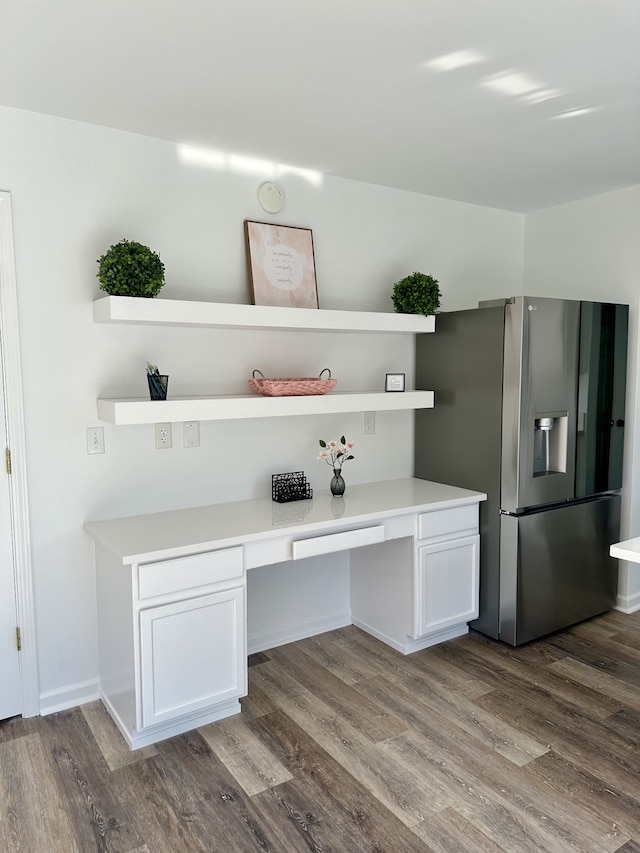 unfurnished office featuring built in desk and wood-type flooring