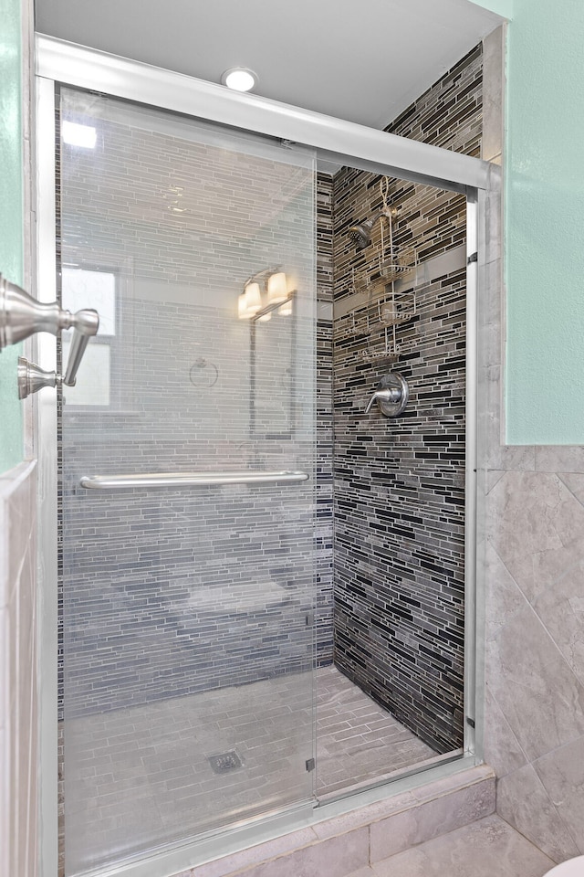 bathroom featuring a shower with door