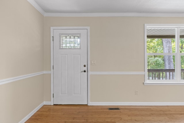 foyer entrance featuring crown molding and light wood-type flooring