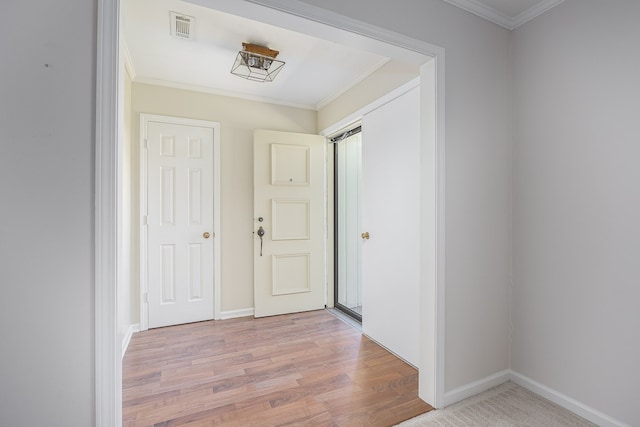 hallway with light hardwood / wood-style floors and ornamental molding