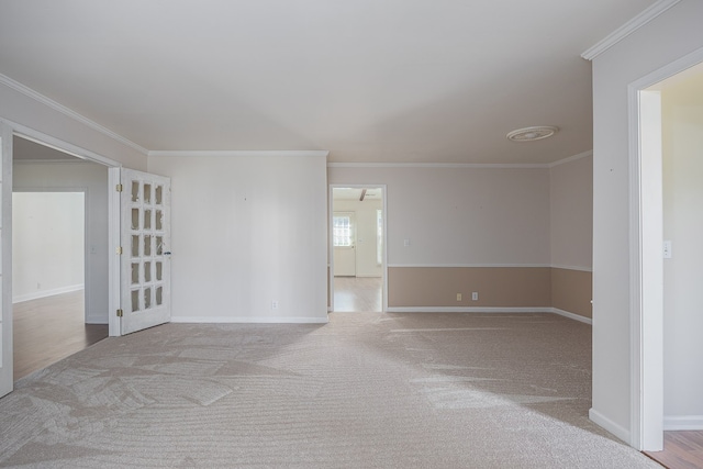 spare room featuring ornamental molding and light colored carpet