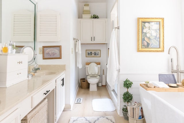 bathroom with hardwood / wood-style floors, vanity, and toilet