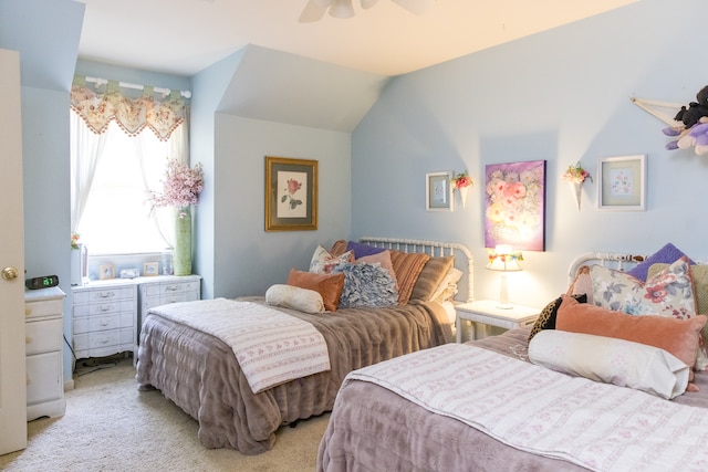 carpeted bedroom with ceiling fan and vaulted ceiling