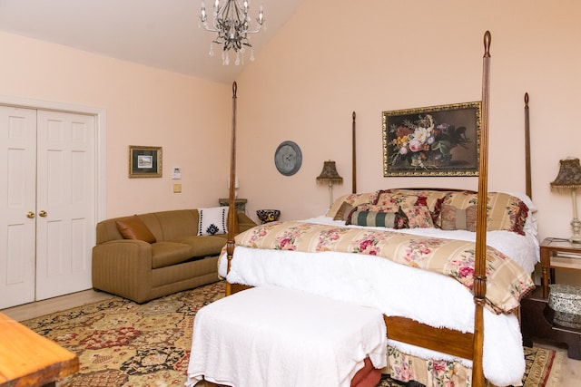 bedroom with a notable chandelier, vaulted ceiling, a closet, and wood-type flooring