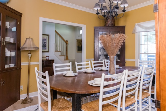 dining area featuring ornamental molding and an inviting chandelier