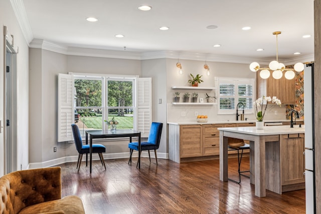 kitchen with a wealth of natural light, dark wood-type flooring, decorative light fixtures, and crown molding