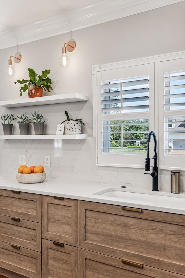 kitchen featuring ornamental molding, sink, and a healthy amount of sunlight