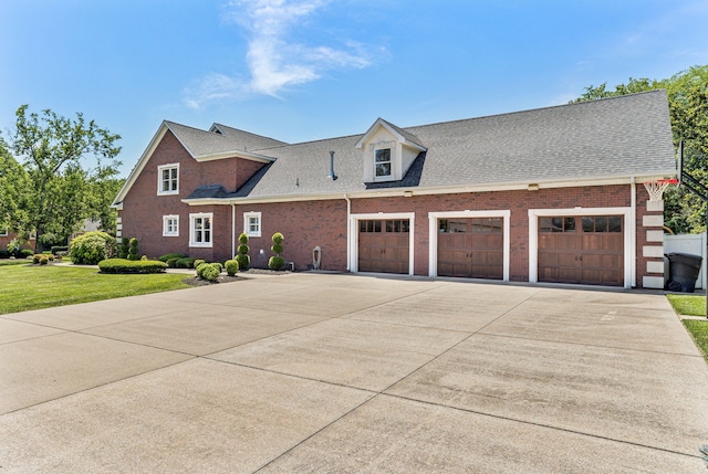 cape cod home with a garage and a front lawn