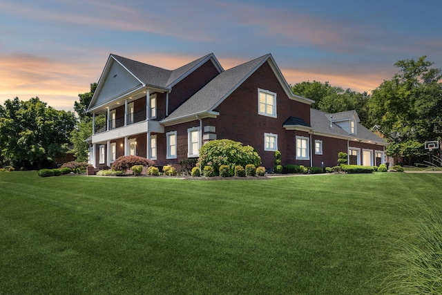 view of front of house with a yard and a balcony